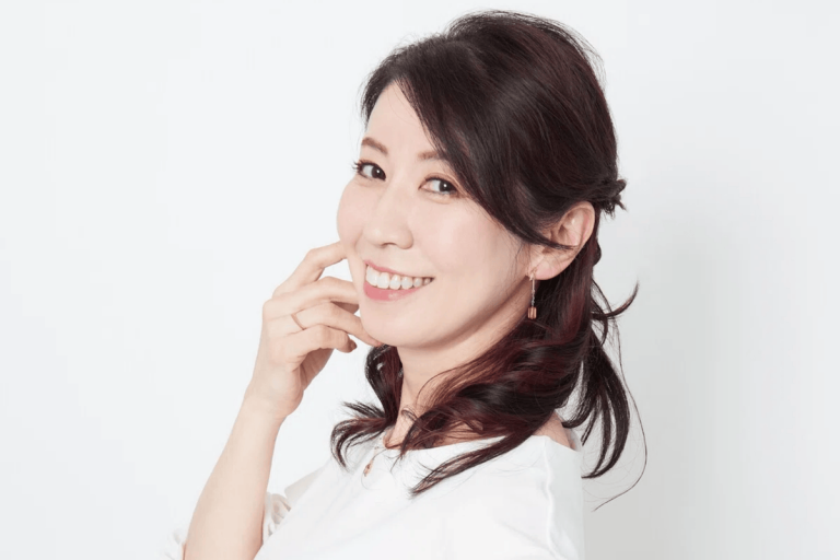 Real portrait of Japanese voice actor Kotono Mitsuishi smiling against a light background