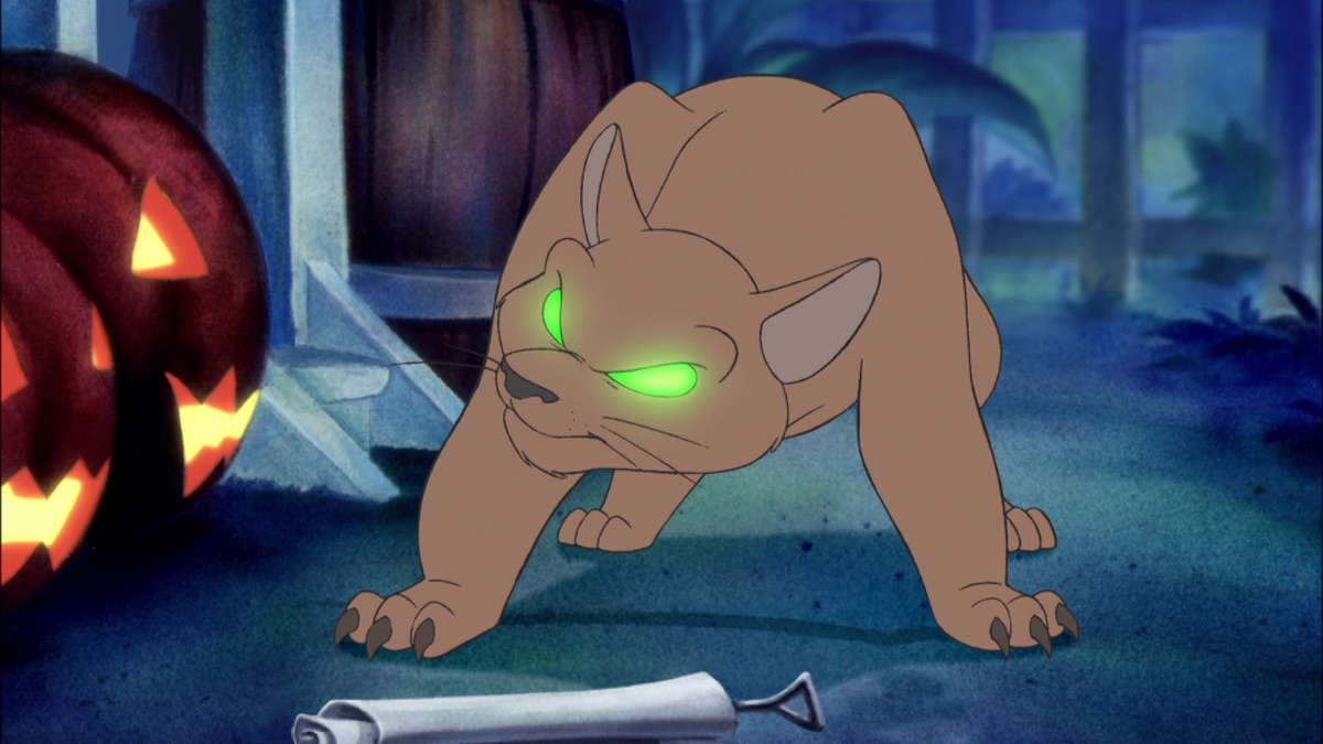 Official episode still of Spooky transformed into a glowing-eyed creature beside a Halloween jack-o-lantern