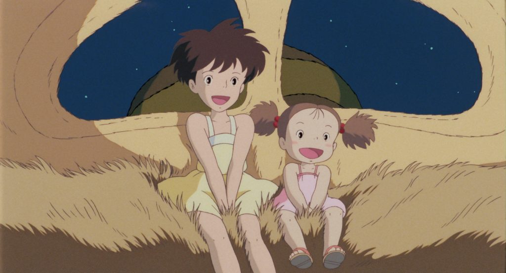Satsuki and Mei sitting together with Totoro