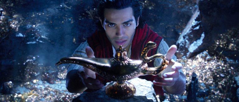 Mena Massoud as Aladdin reaches toward the magic lamp in an official Disney still