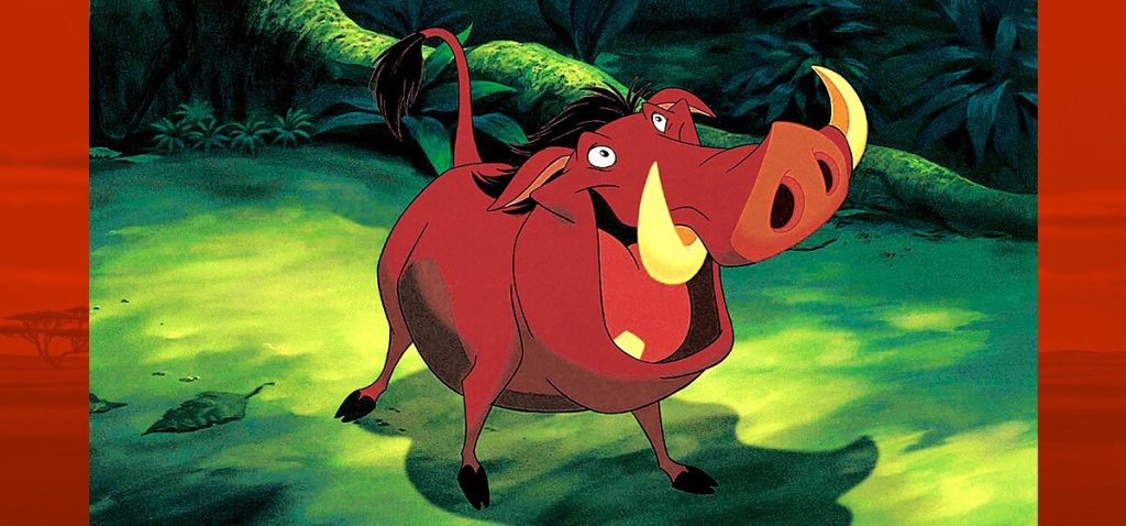 Pumbaa smiles in the jungle in an official Disney still